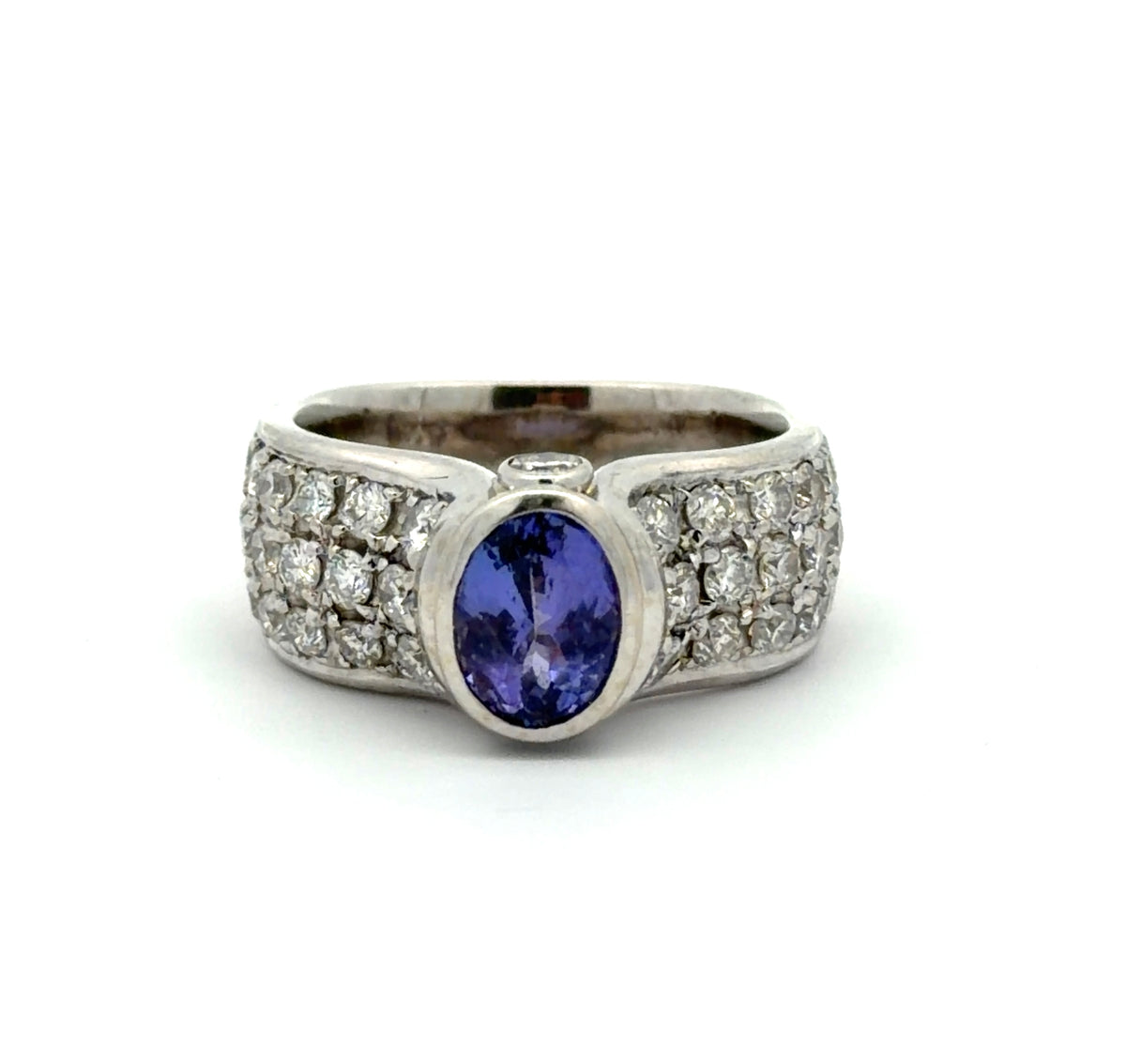 White gold ring with a Tanzanite oval gemstone and diamond accents on a white background