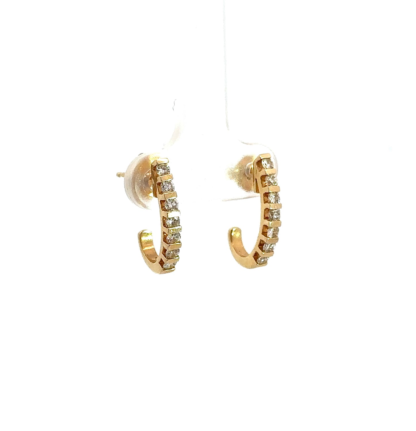 Diagonal view of yellow gold earrings with 7 small round diamonds on each ear with a curved detail and open back.
