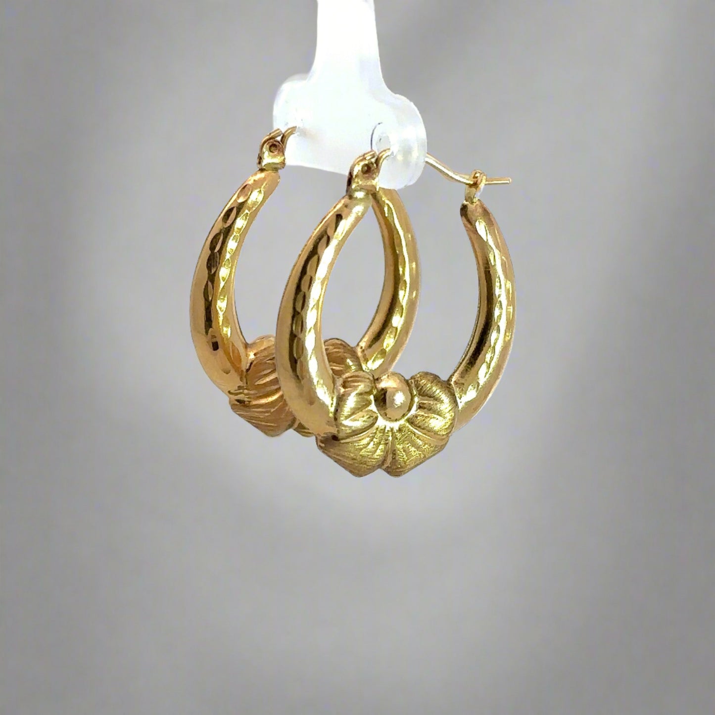 Diagonal view of yellow gold bow hooops