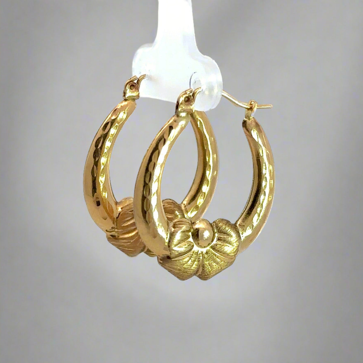 Diagonal view of yellow gold bow hooops