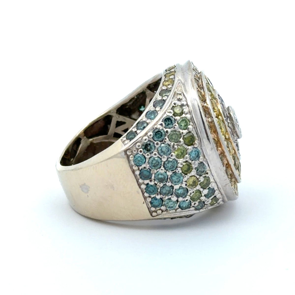 White gold ring with yellow, white, blue, & green diamonds on a white background