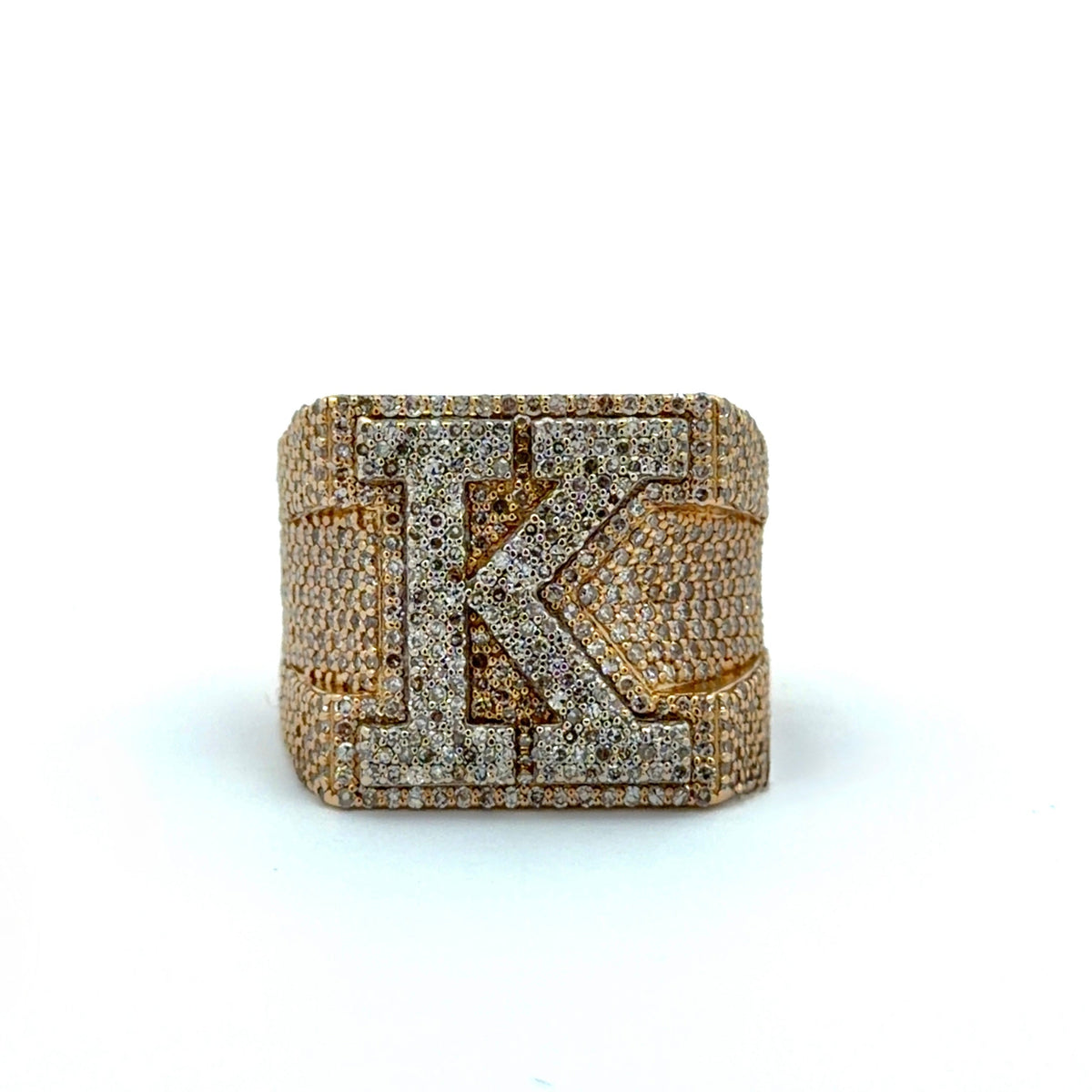 Gold and diamond-encrusted ring with a prominent 'K' on a white background