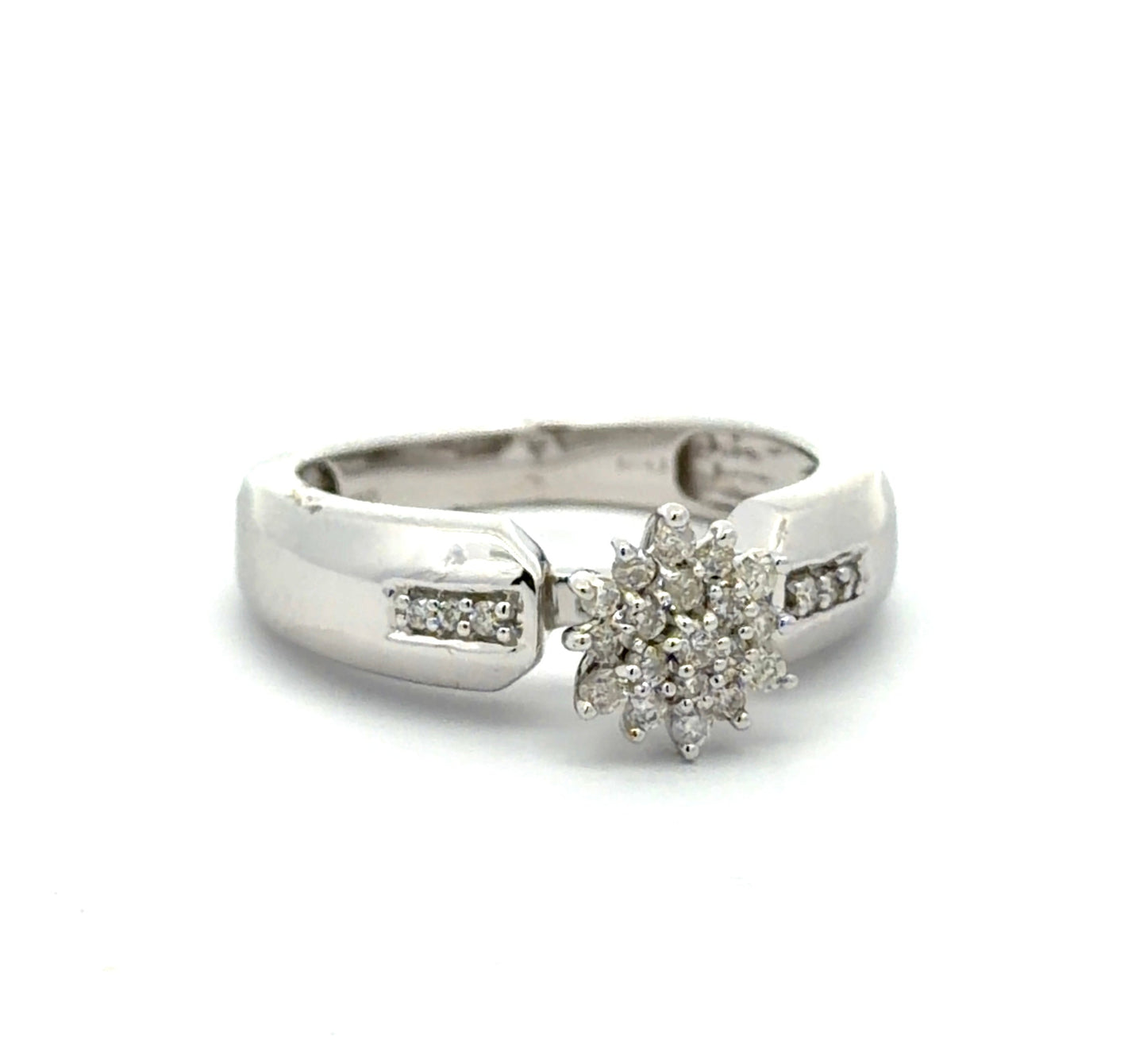 White gold ring with diamond flower design on a white background