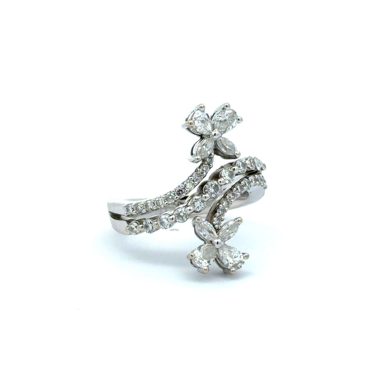 Diagonal view of white gold ring with diamond floral accents on a white background