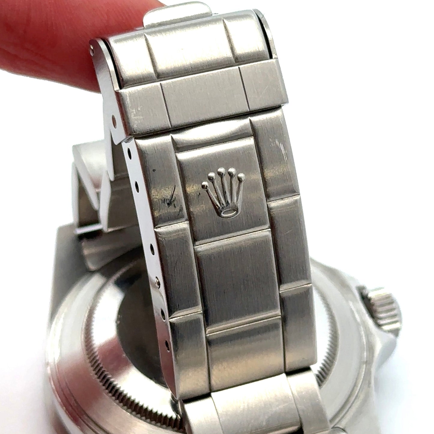 Close-up of a silver Rolex watch band with a white background