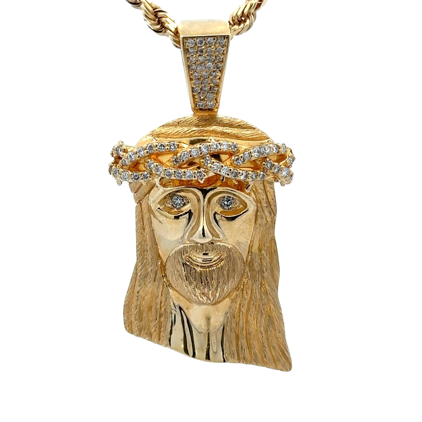 close up of yellow gold jesus head pendant with small round diamonds on the crown, bail, and eyes