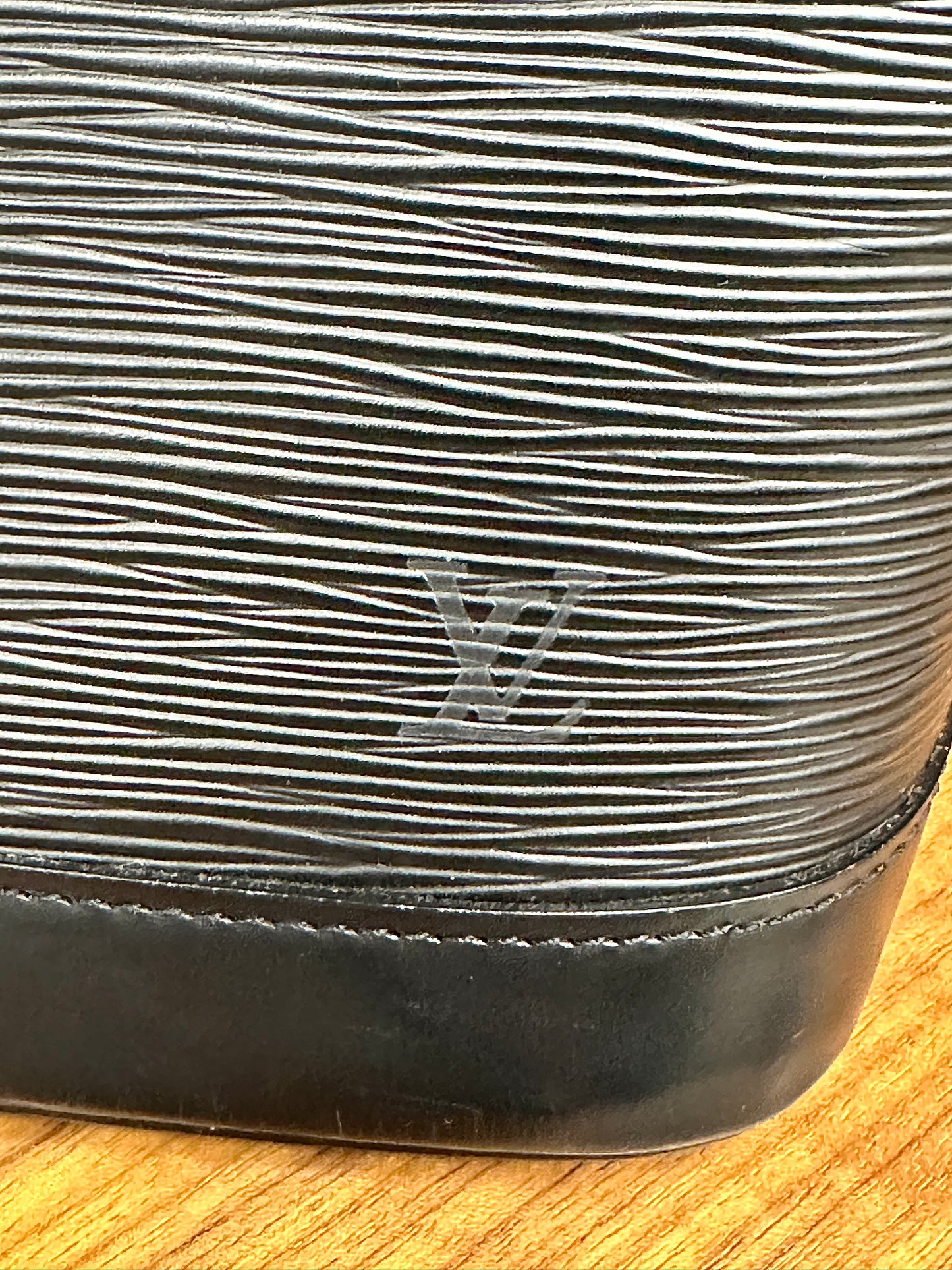 LV logo on corner of bag with scuff marks 
