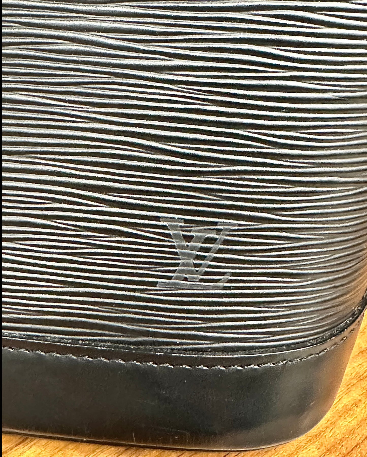 LV logo on corner of bag with scuff marks