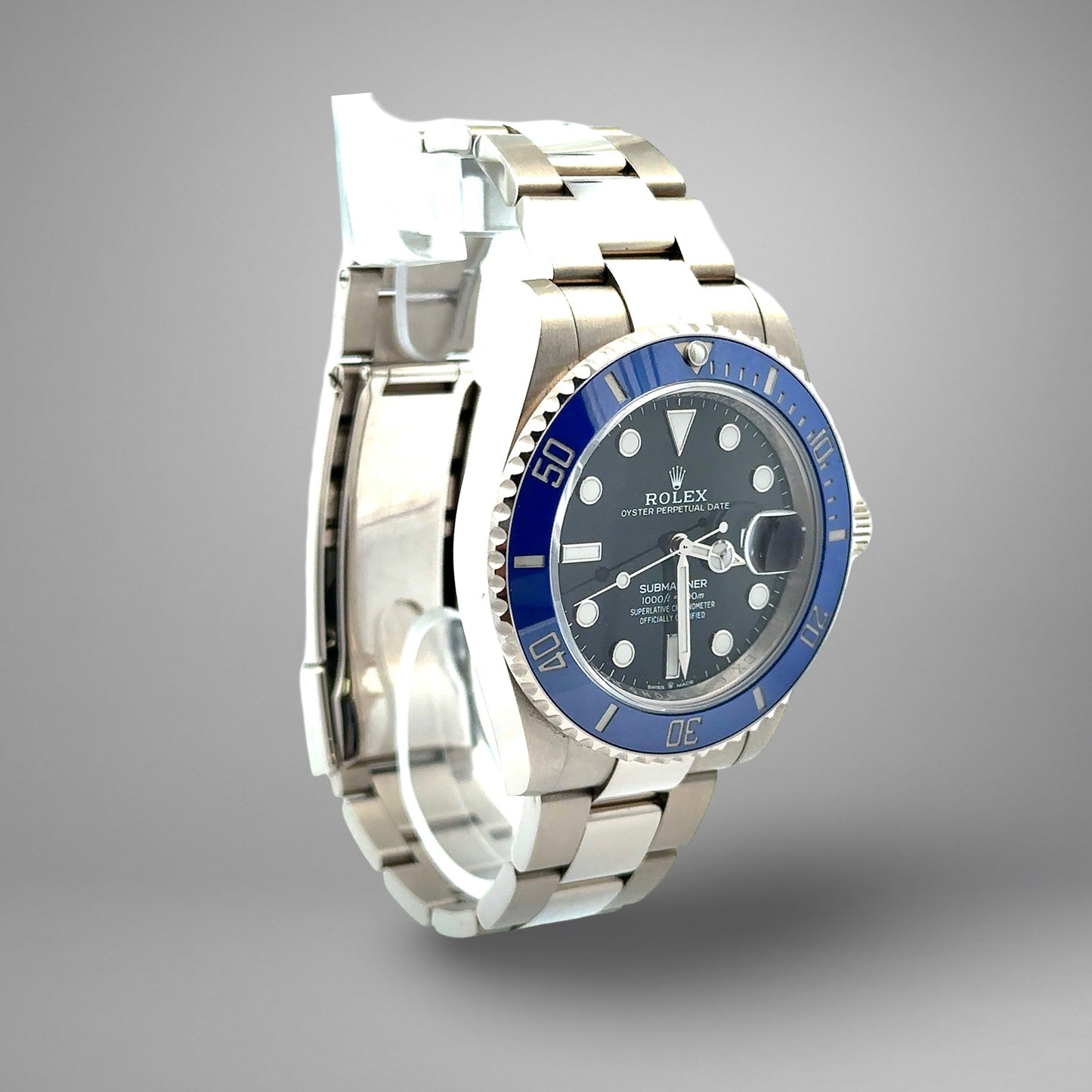 Silver watch with blue bezel and black face on a gray background