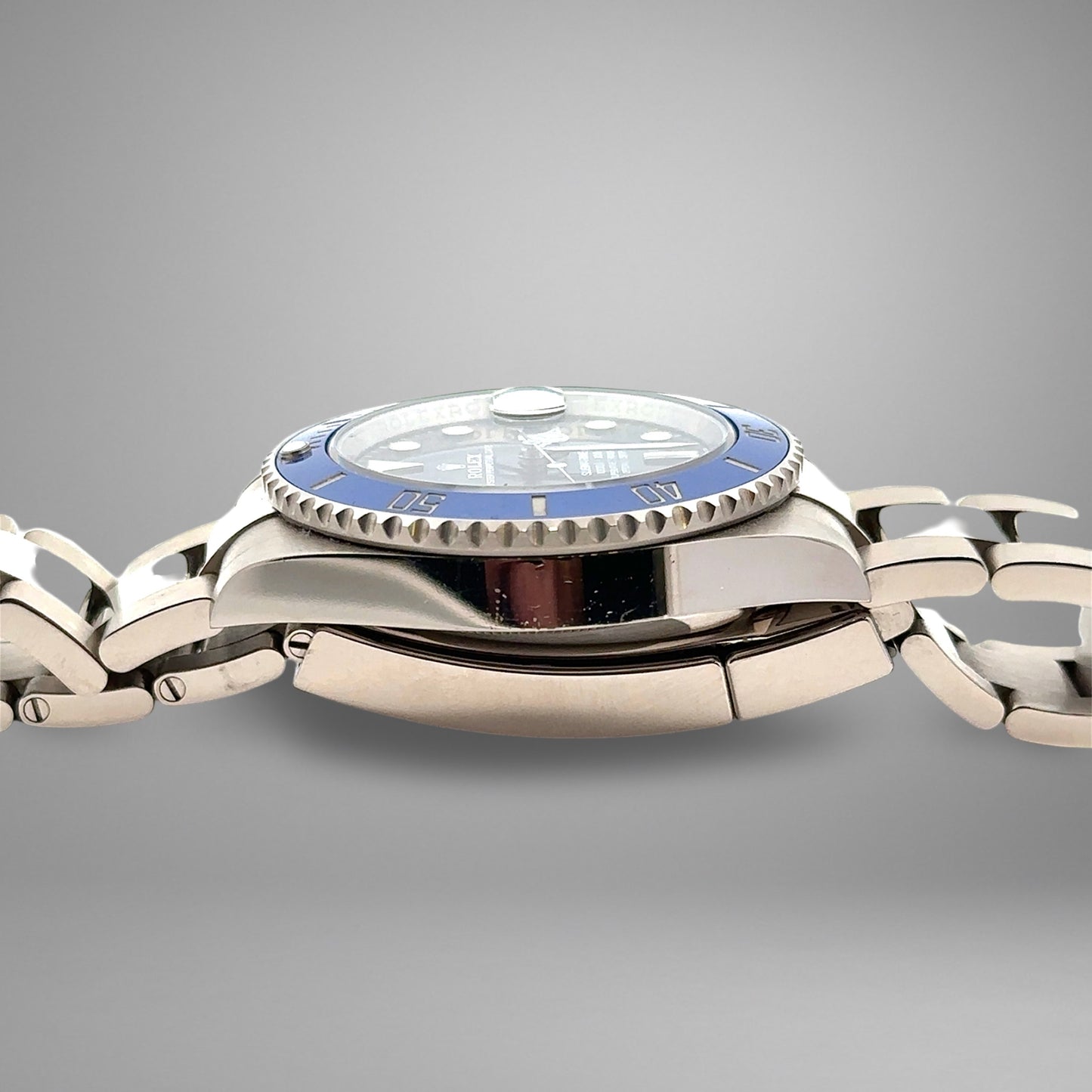 Silver watch with a blue face on a gray background. Nicks on case.