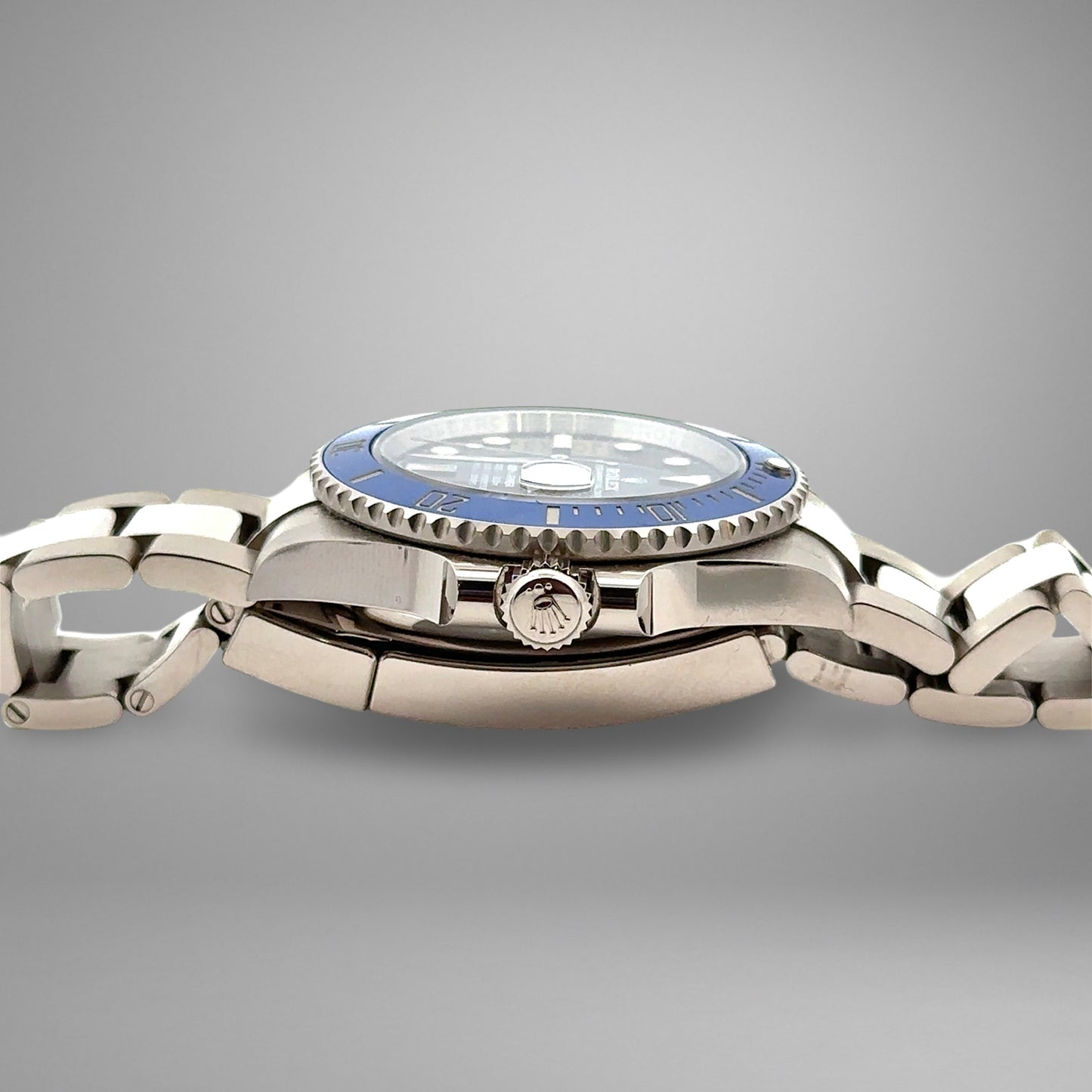 Silver watch with a blue bezel on a gray background