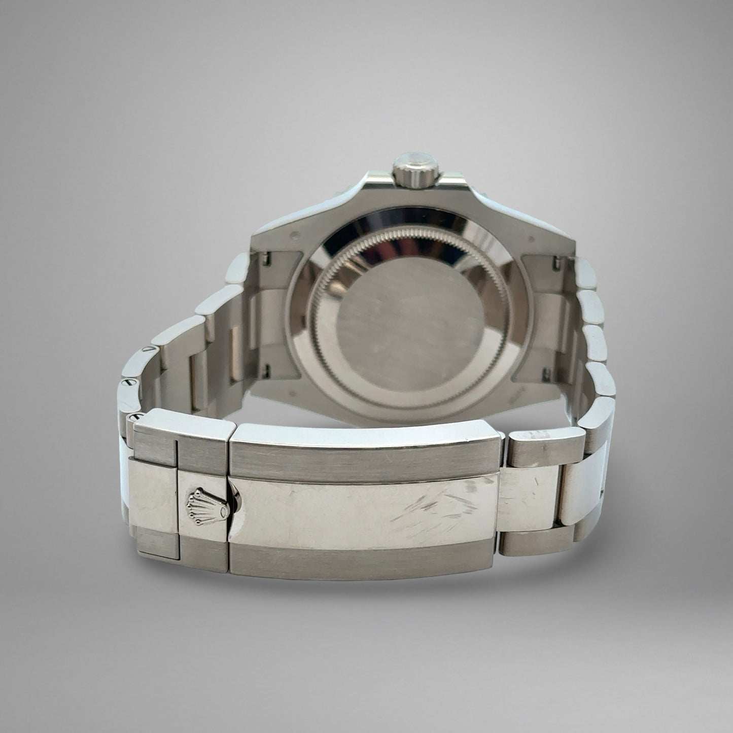 Silver watch case on a gray background