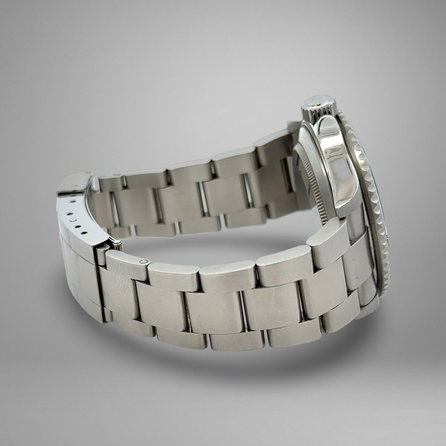 Silver metal watch strap on a gray background