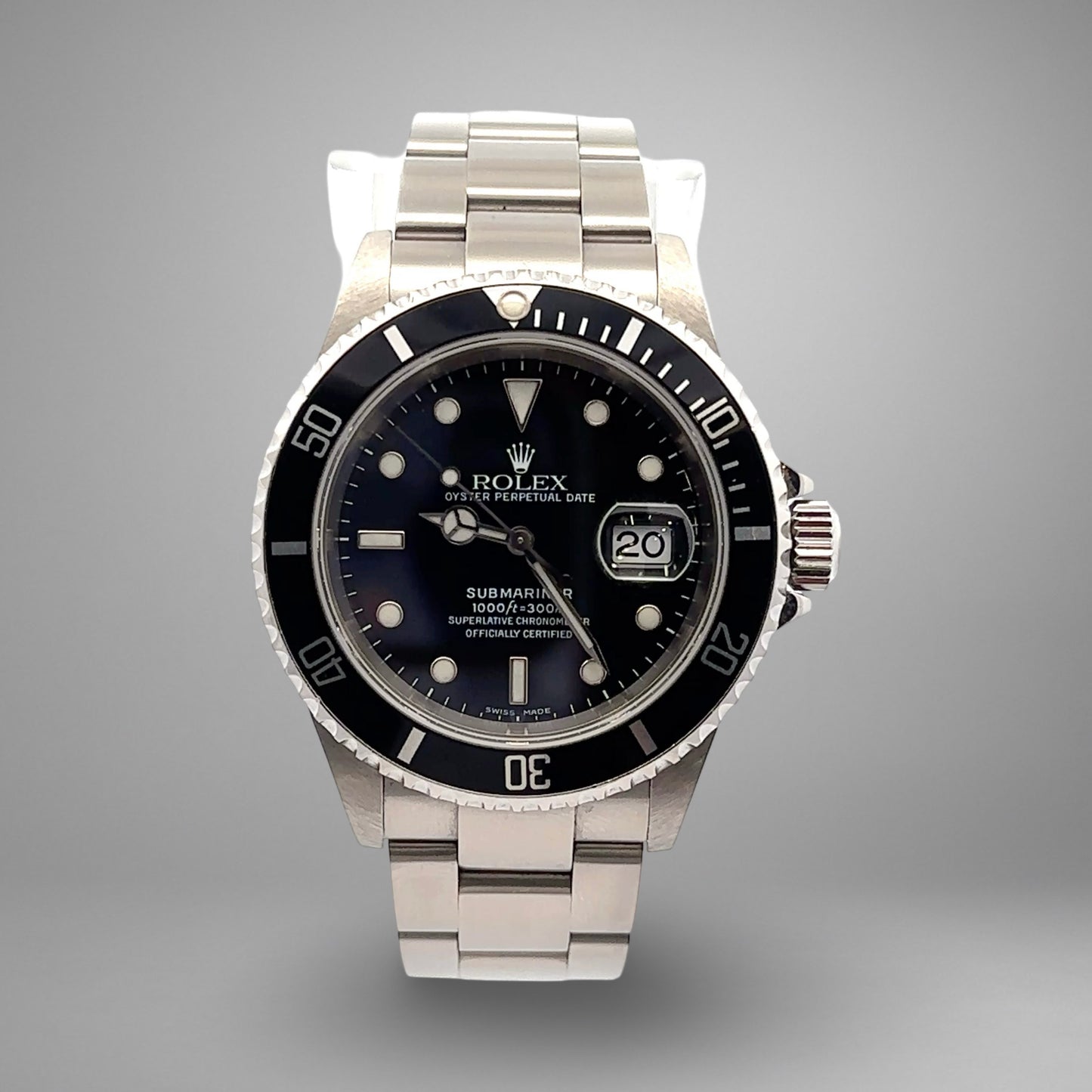 Silver Rolex watch with black dial on a gray background