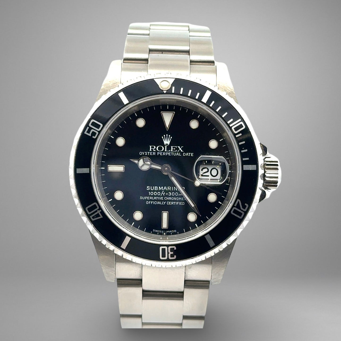 Rolex Submariner watch with black dial and silver metal bracelet on a gray background