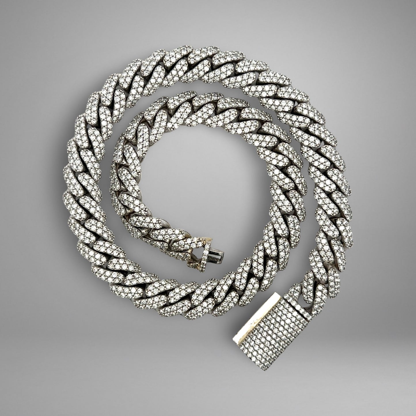 Silver chain necklace with a clasp on a gray background
