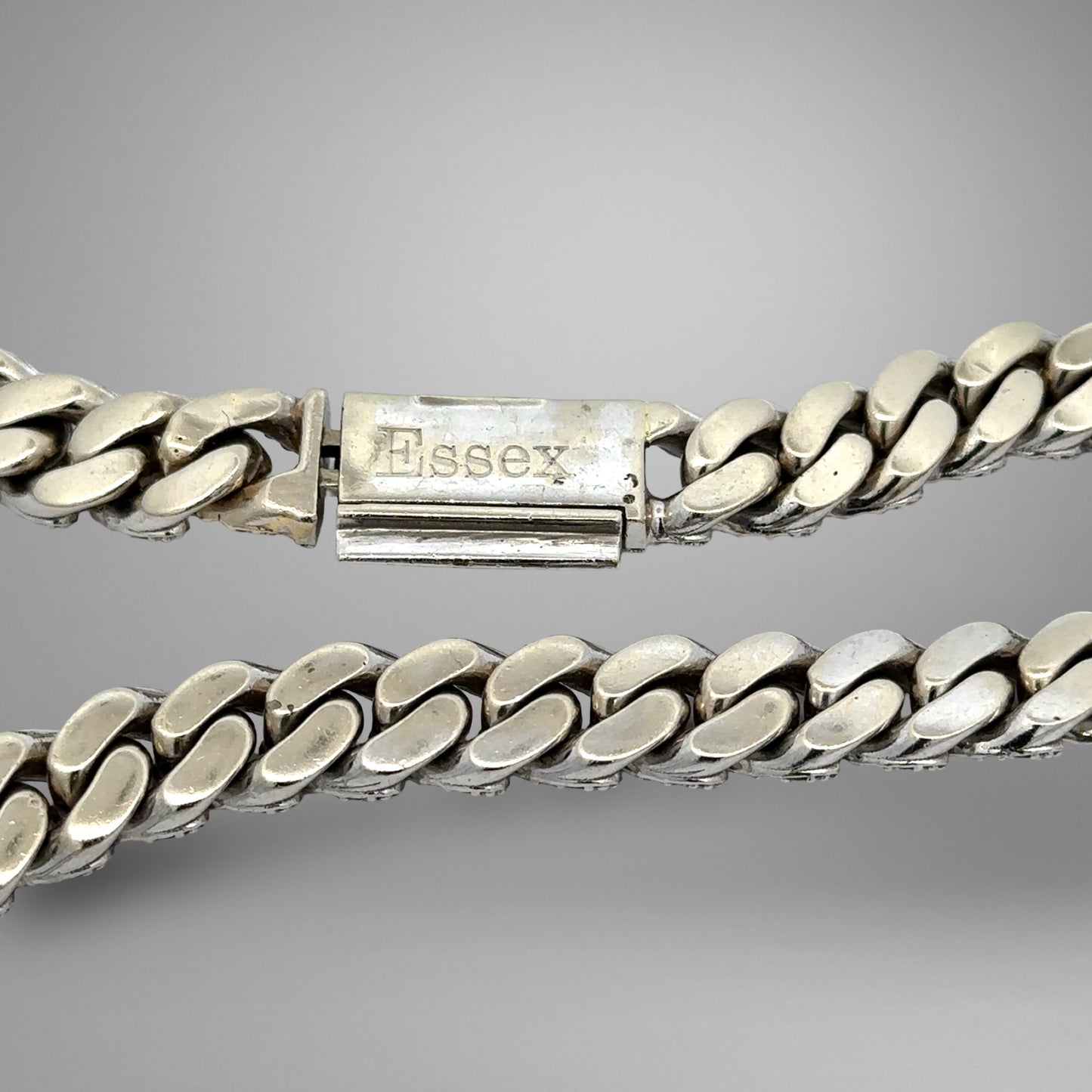Silver chain bracelet with 'Essex' clasp on a gray background