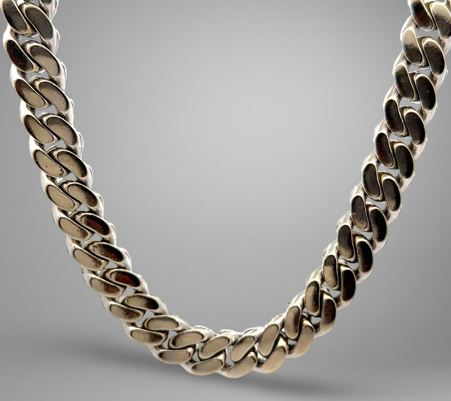 Silver chain necklace on a gray background