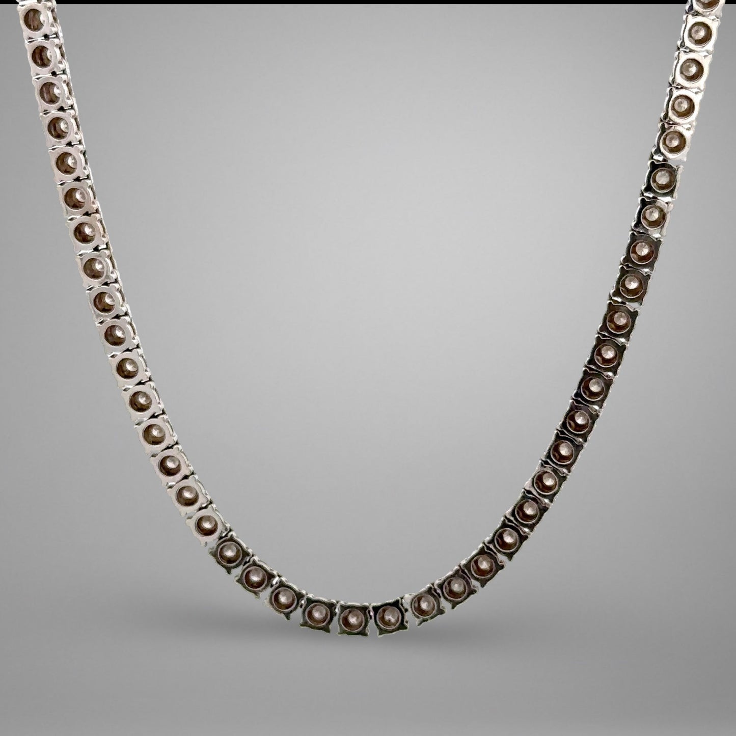 Silver necklace with brown beads on a gray background