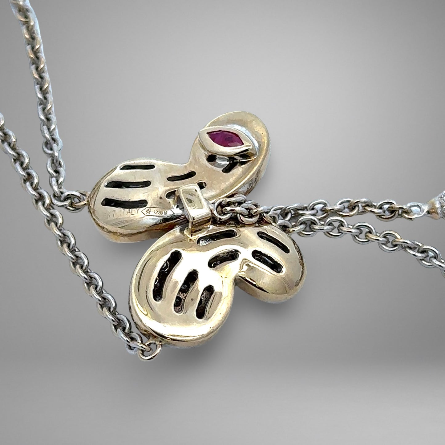 White Gold necklace with a butterfly pendant on a gray background