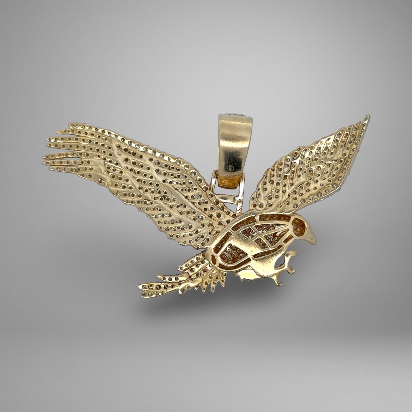 Gold eagle pendant on a gray background