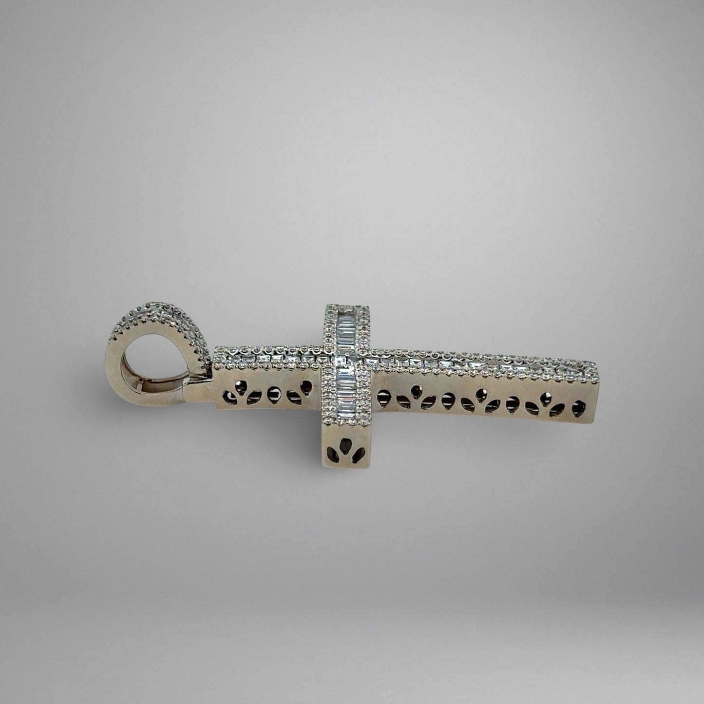 Silver cross pendant with diamonds on a gray background