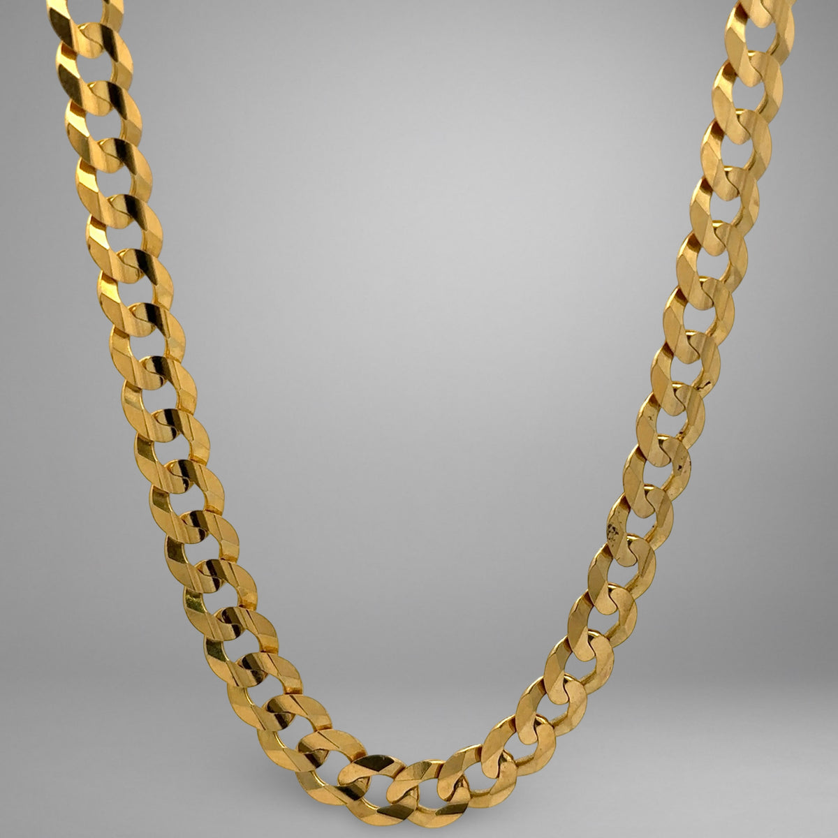 Gold chain necklace on a gray background