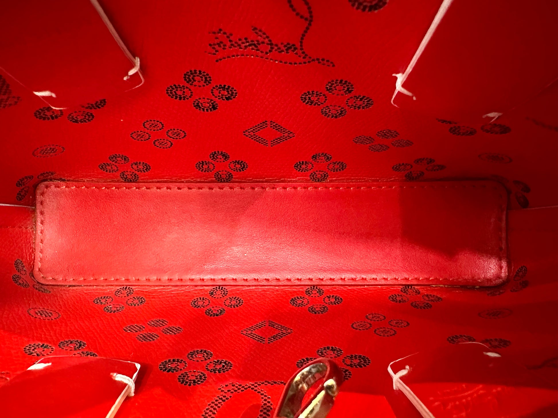 Close up red interior of bag with black Louboutin + CL signature 