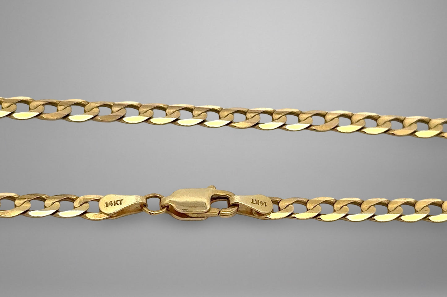 Gold chain with a clasp on a gray background