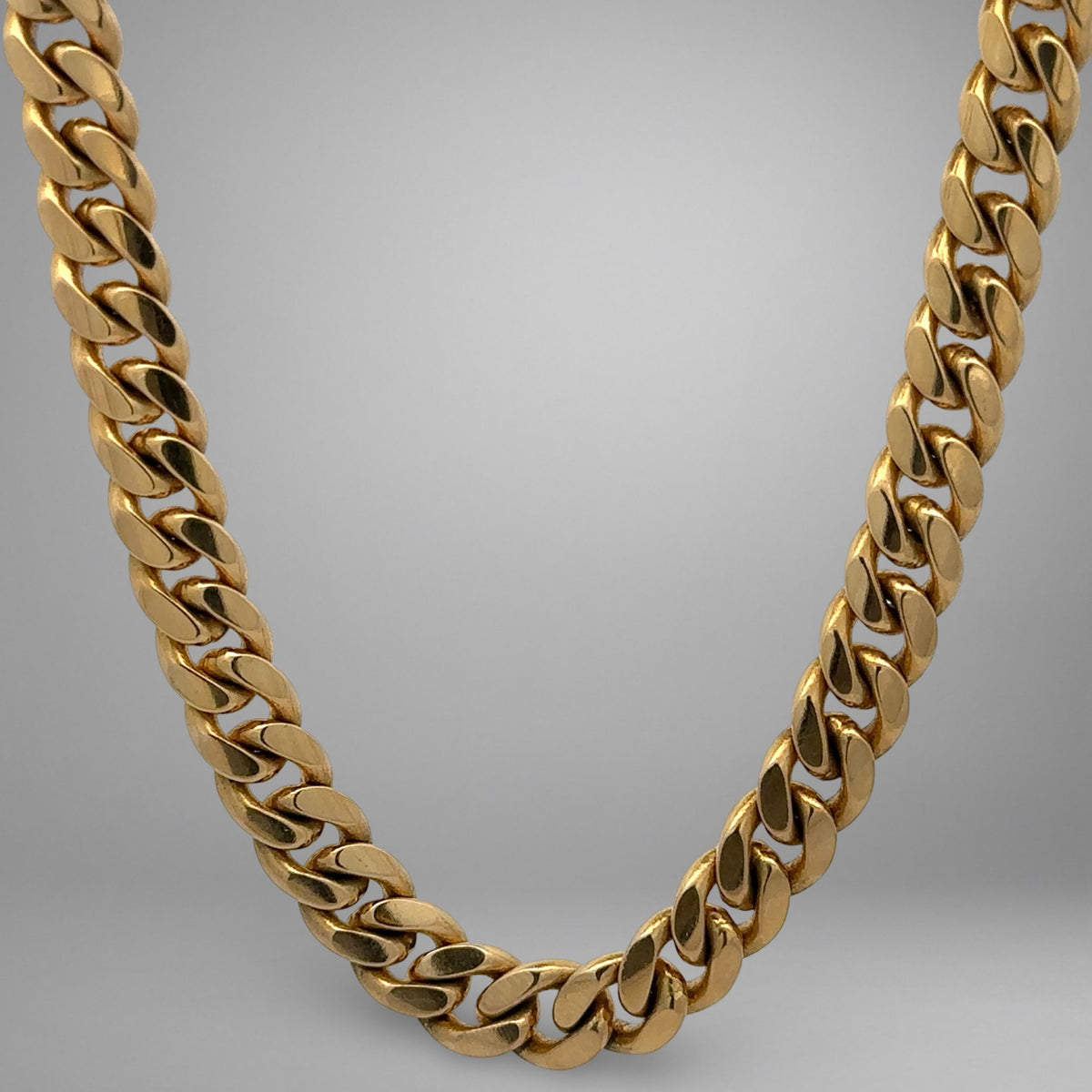 Gold chain necklace on a gray background