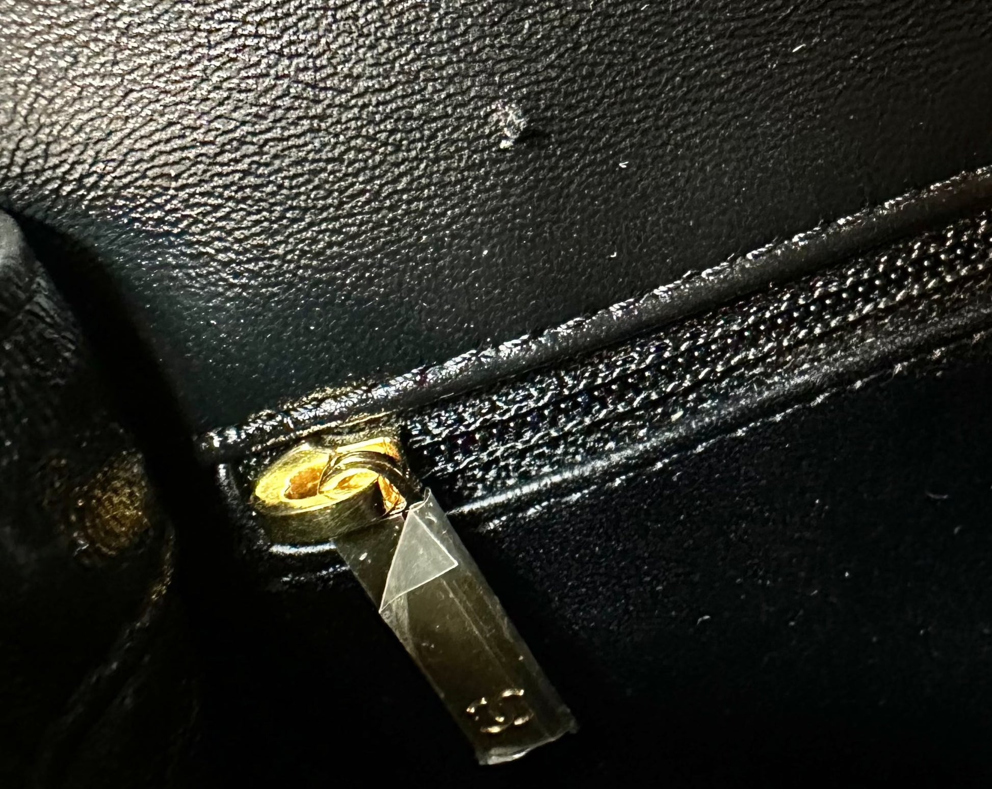 Cut on leather above interior zipper pocket