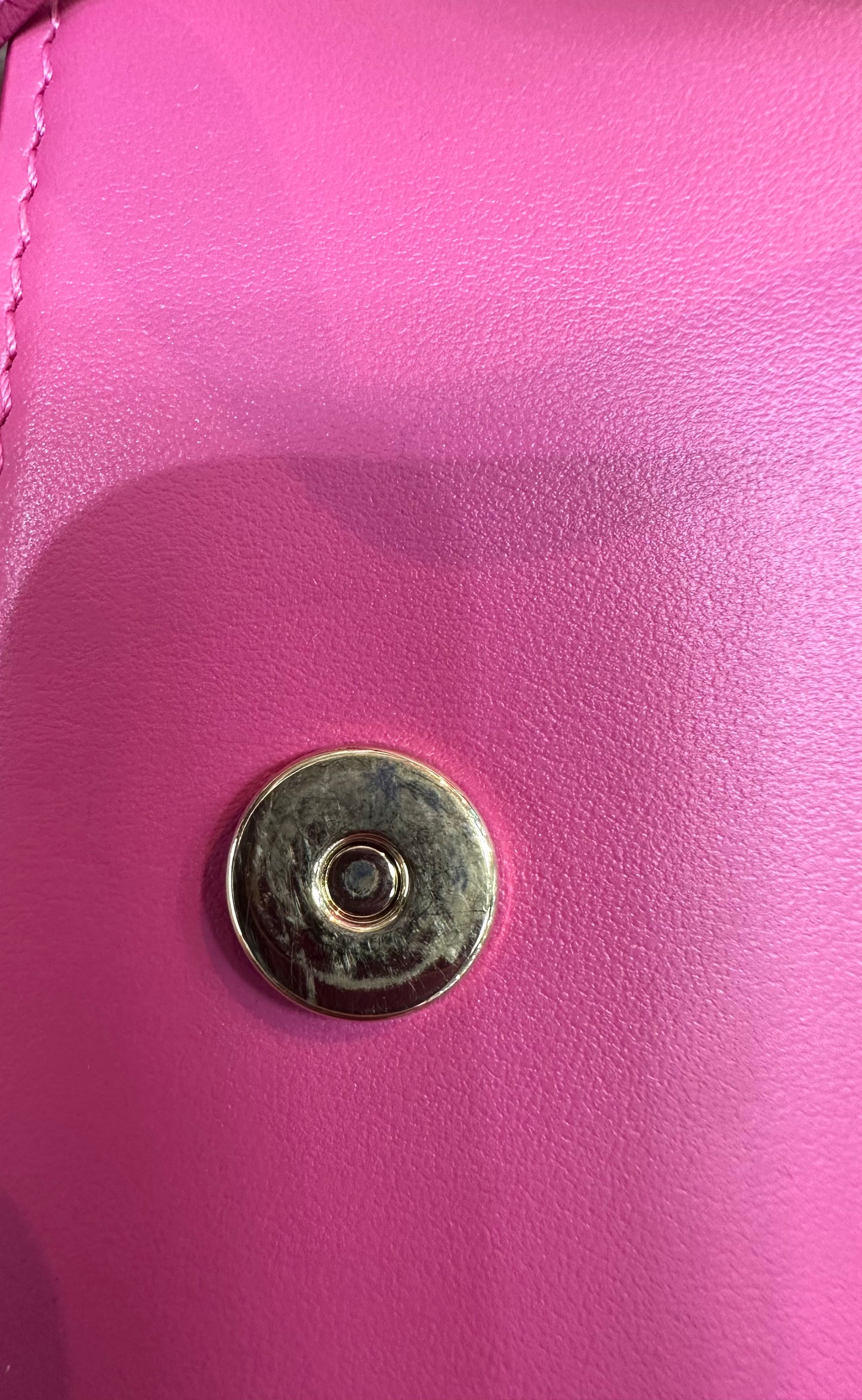 Close up of button closure on the front with scratches on inside of button