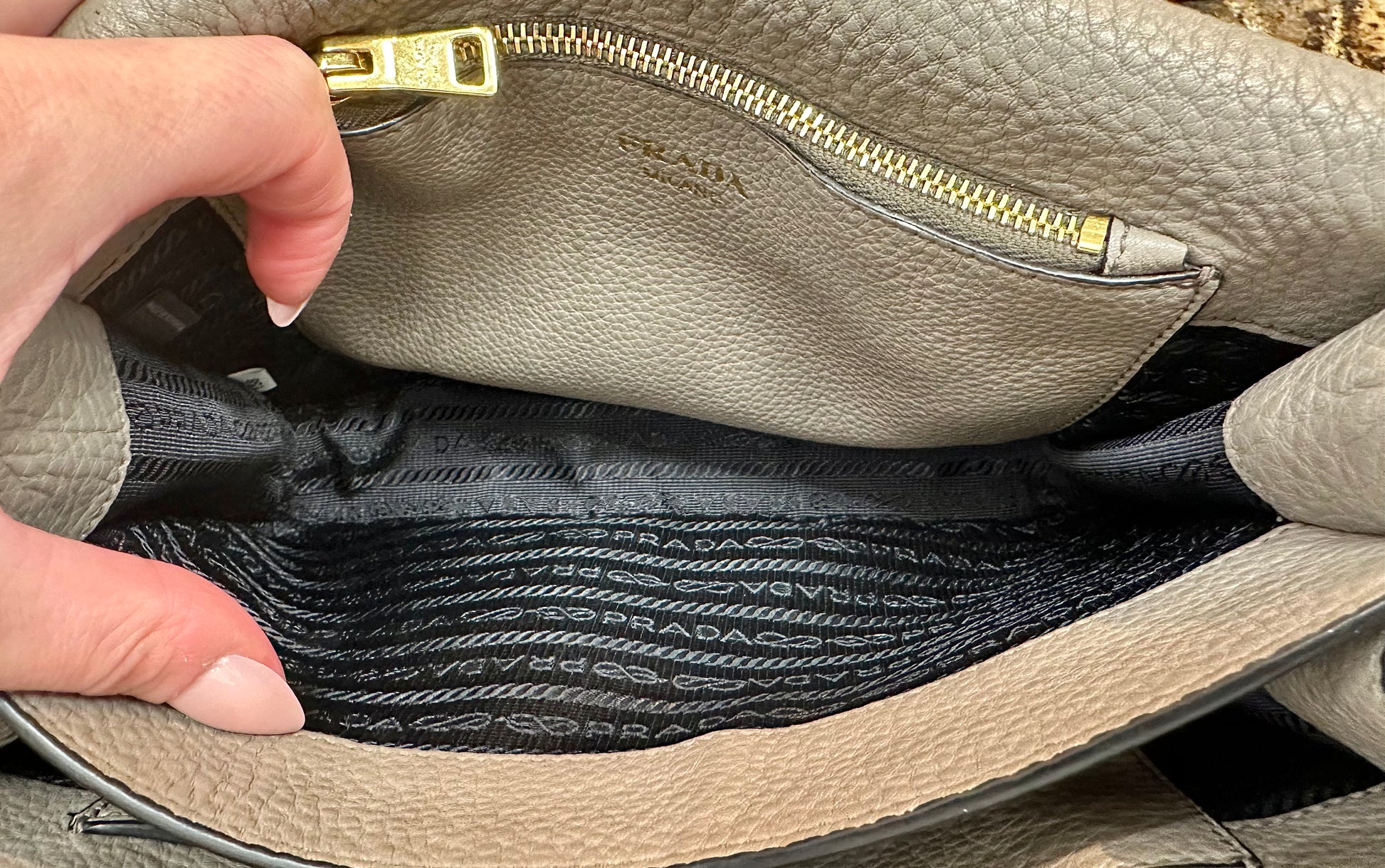 Interior of compartment with side zipper pocket and black prada logo lining