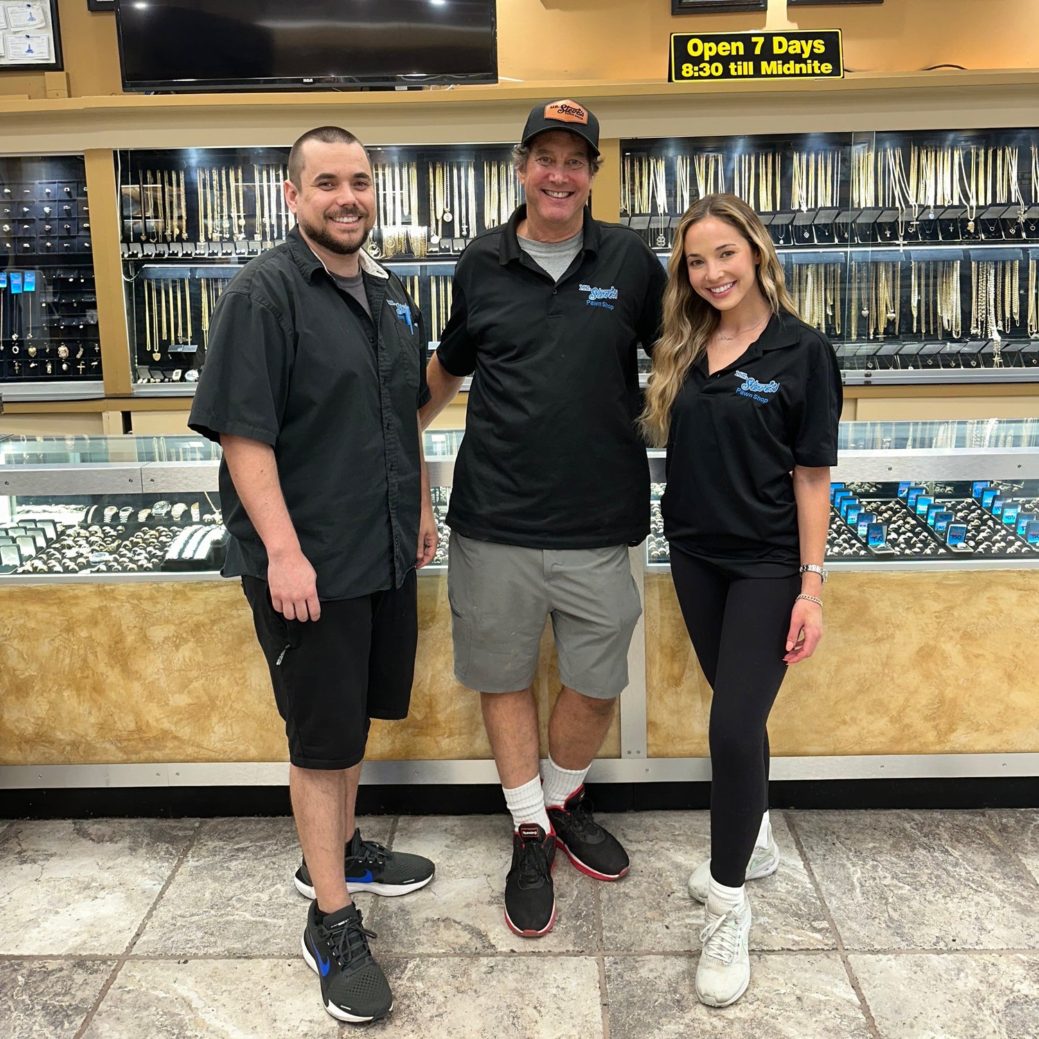 A son, father, and daughter smiling wearing Mr. Steve's Pawn Shop polos.
