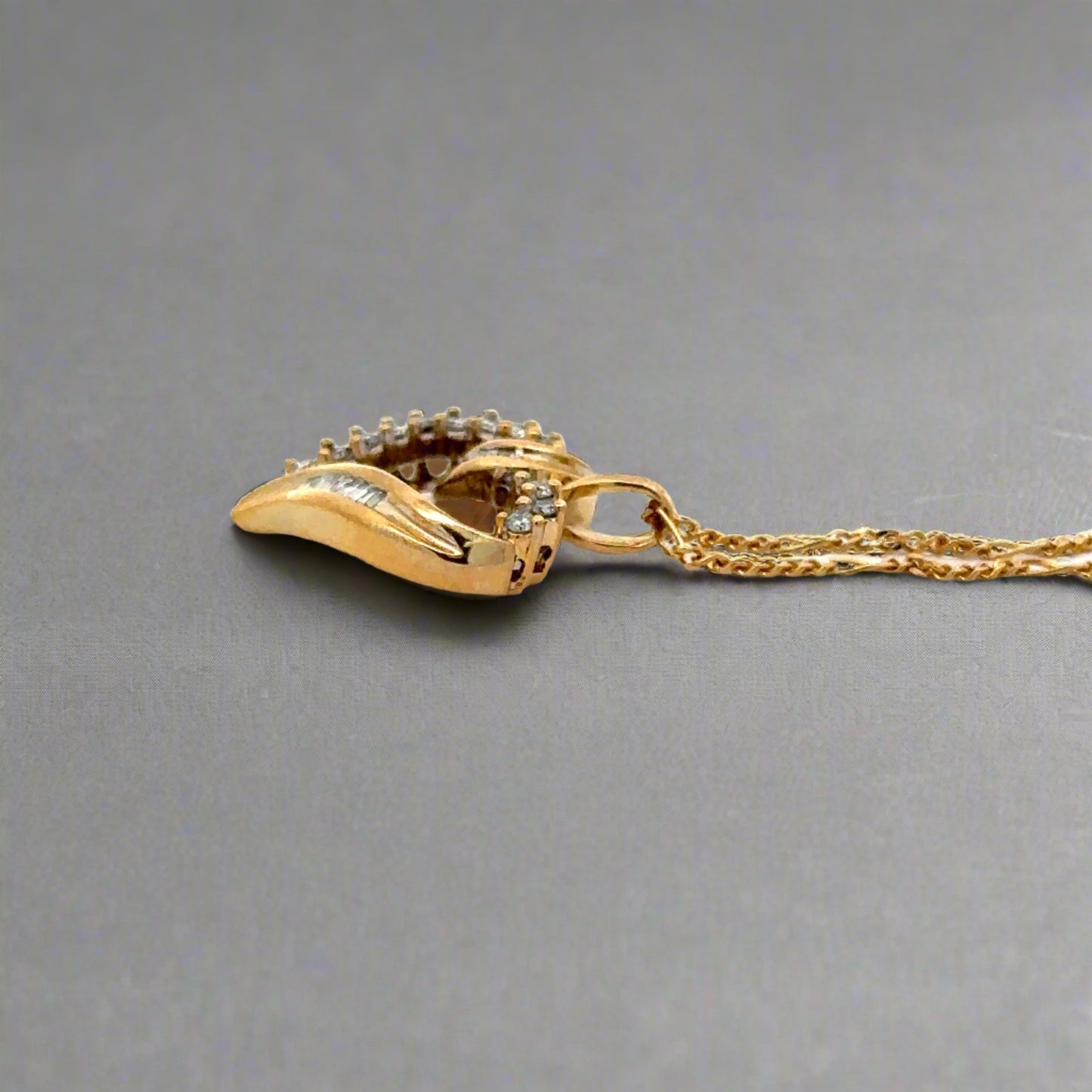 side of yellow gold heart with round bail