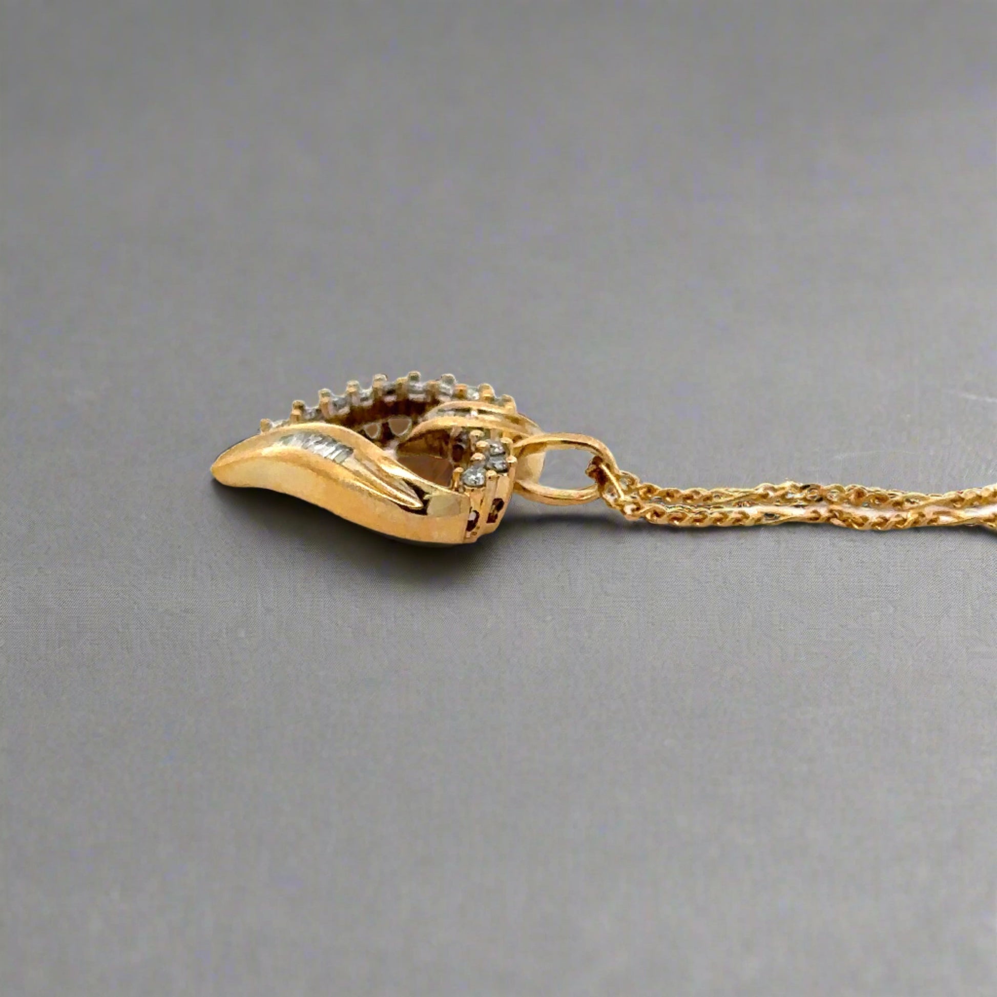 side of yellow gold heart with round bail