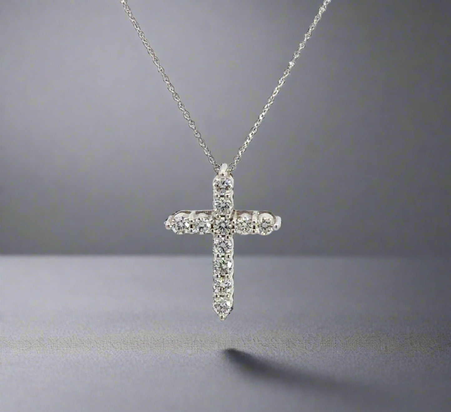 front of white gold diamond cross necklace with 11 small round diamonds