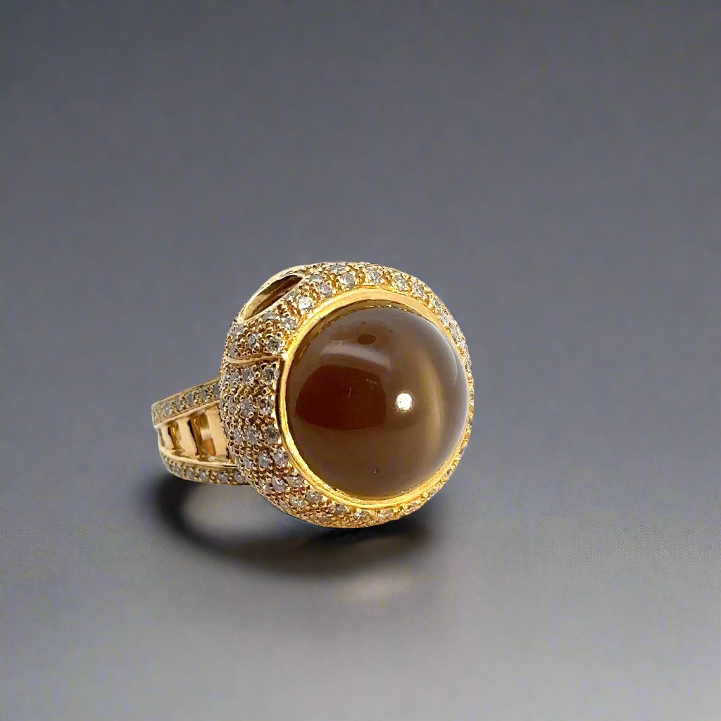The cat's eye effect on the top of the brown stone. This gemstone has a white line across the top when a light is shown on it.