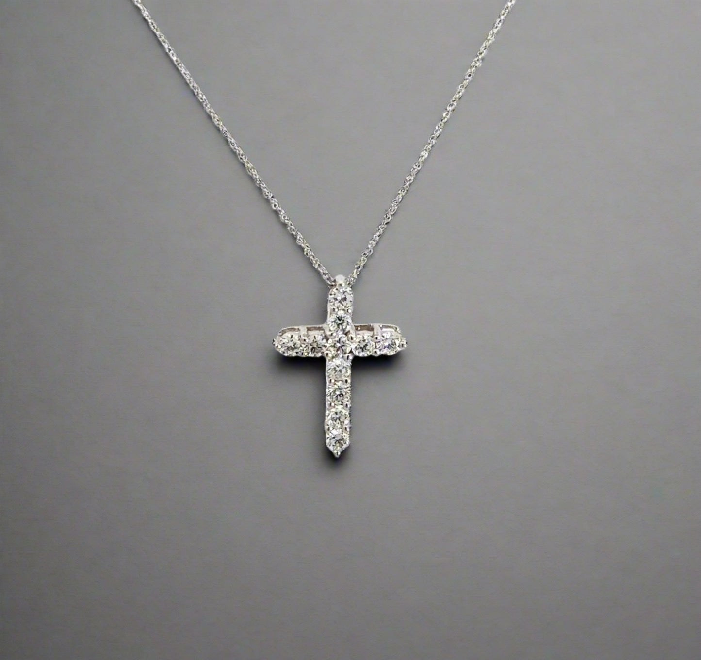 front of white gold diamond cross necklace