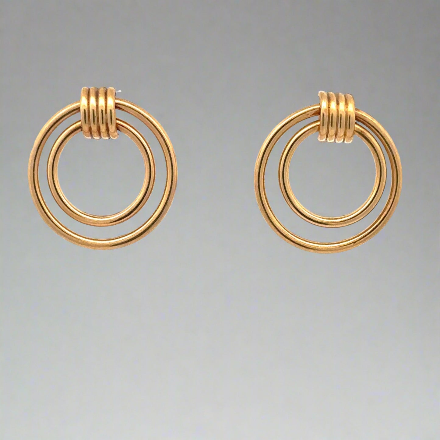 Front of yellow gold stud earrings with 2 circles, 1 smaller, 1 bigger.