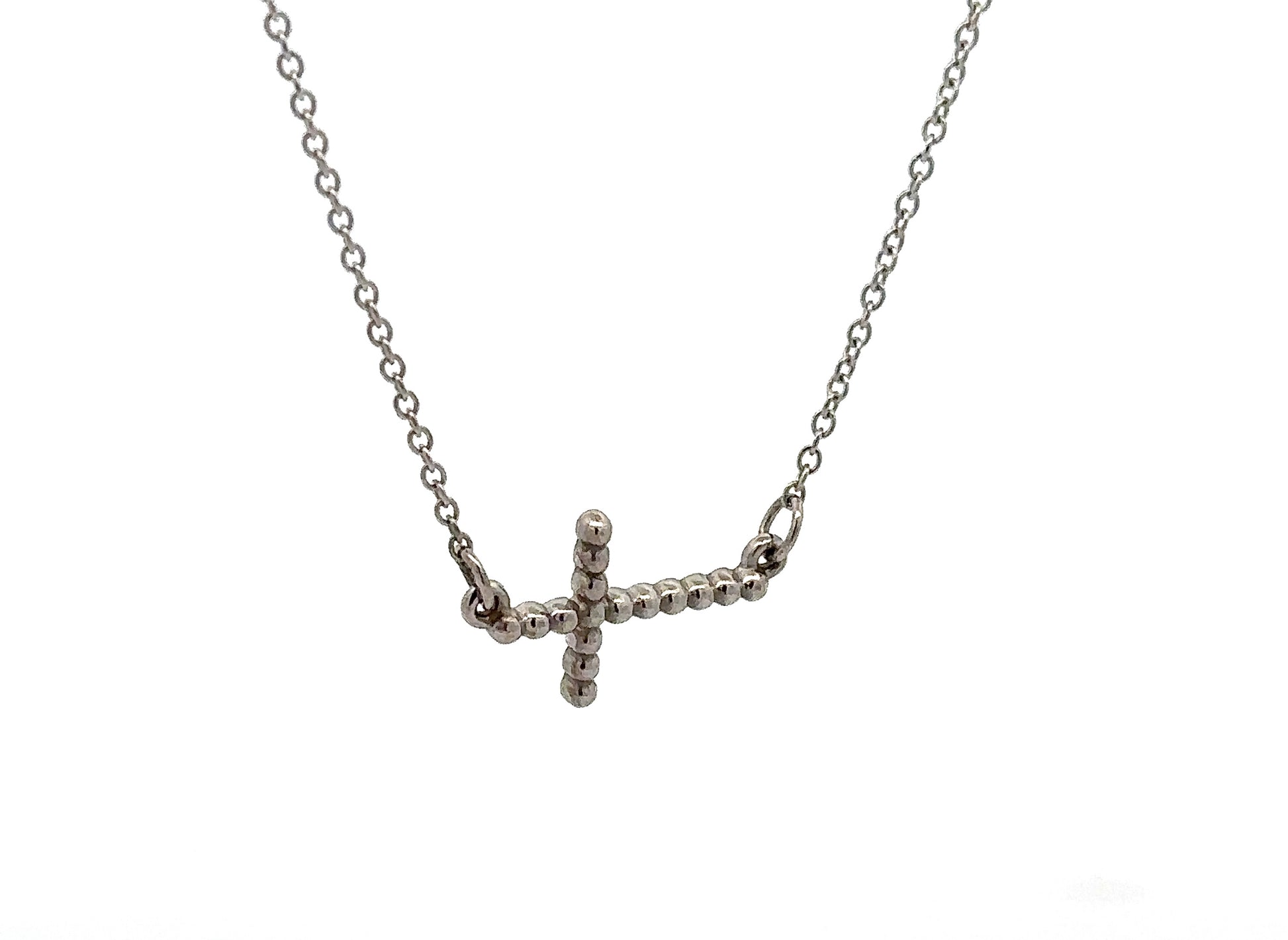Diagonal view of white gold cross necklace