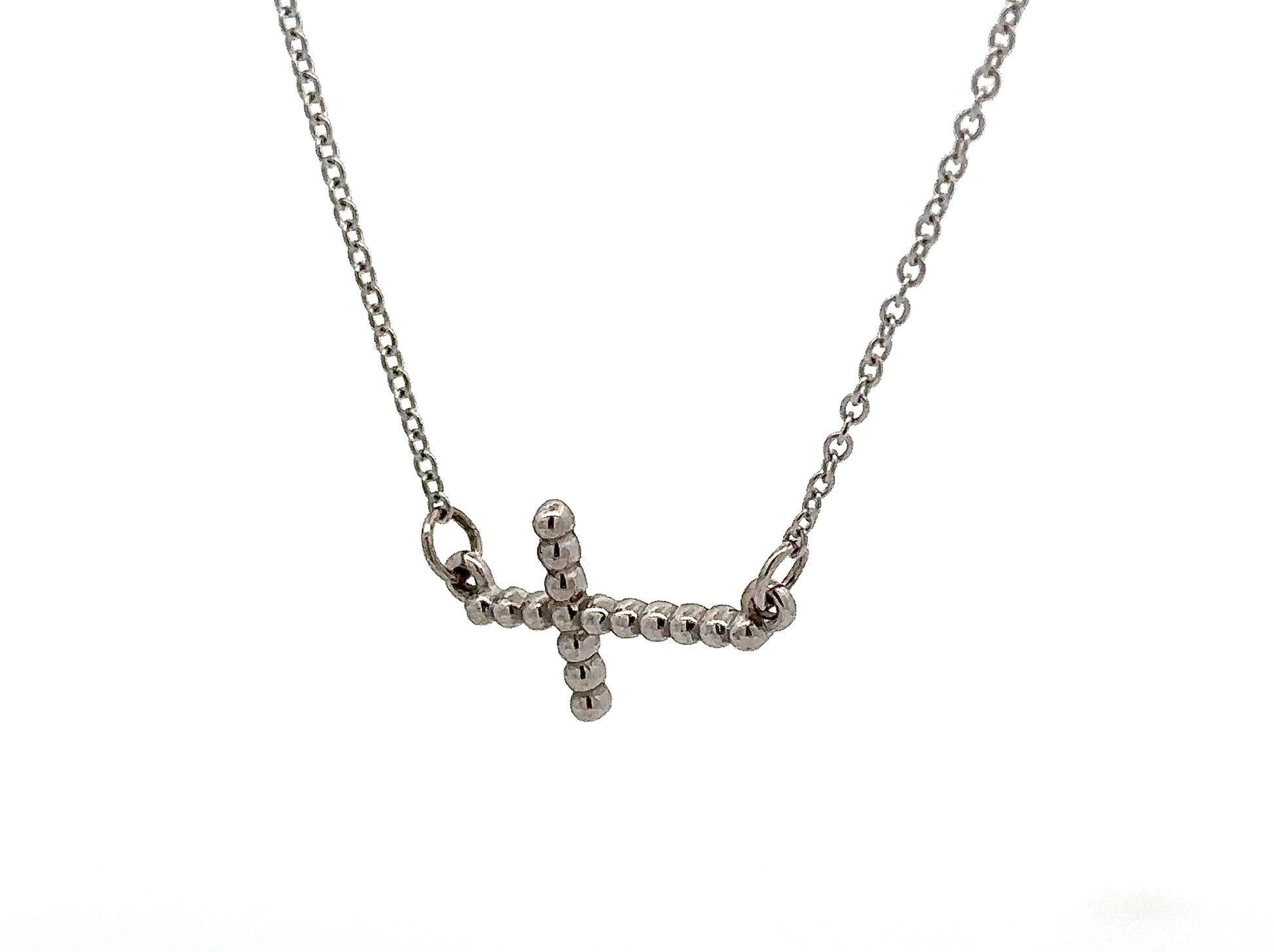 Diagonal view of white gold cross necklace