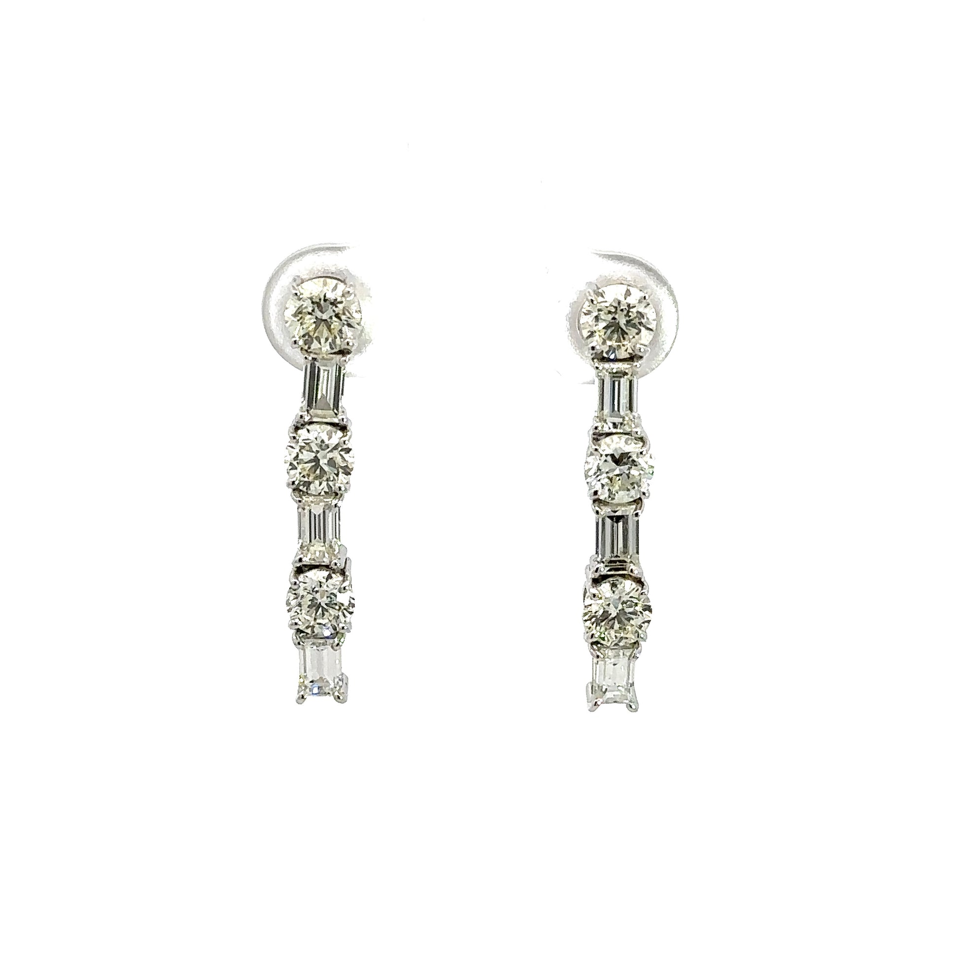 Front of white gold diamond drop errings with 3 round diamonds alternating with 3 emerald-cut diamonds on each earring.