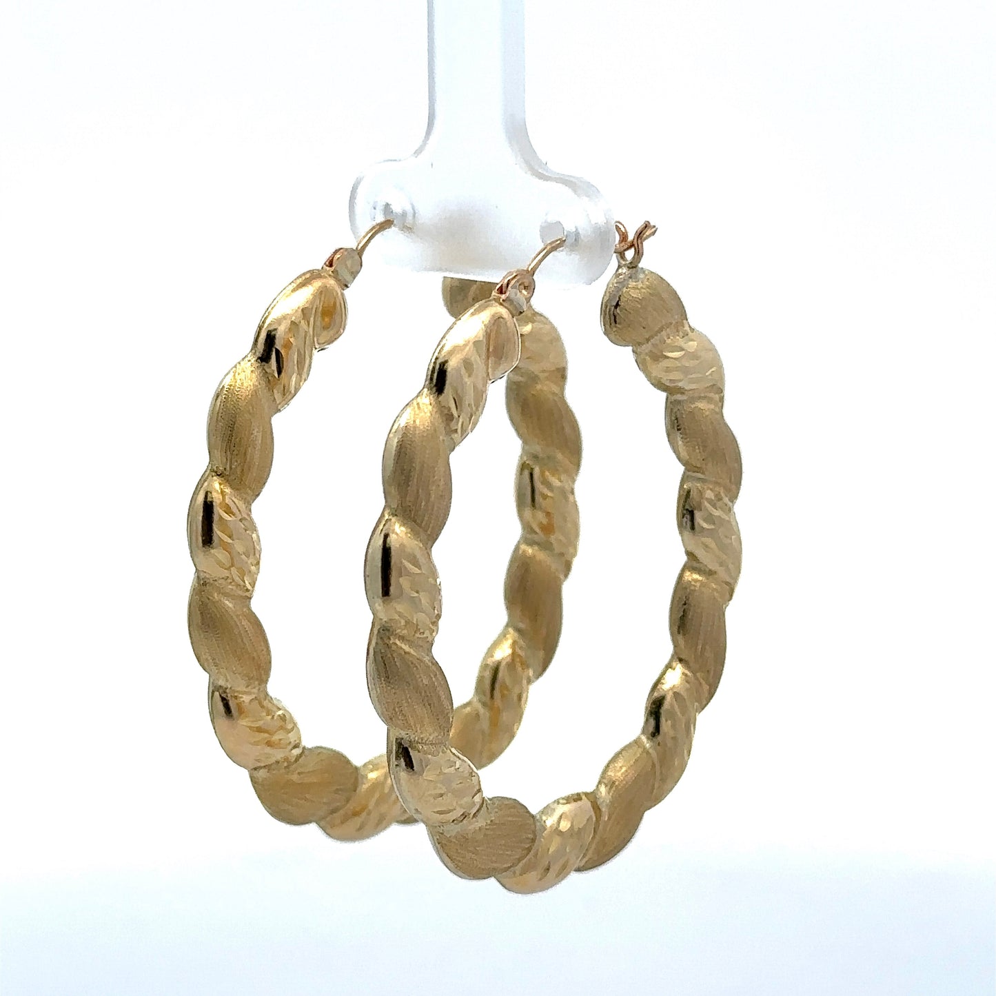 diagonal view of yellow gold twist puff hoops