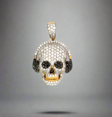 Front of the Diamond musical skull pendant. Black diamonds on headphones, eyes, and nose. Colorless diamonds on skull head, band of headphones, and barrel. Smiling showing yellow gold teeth.