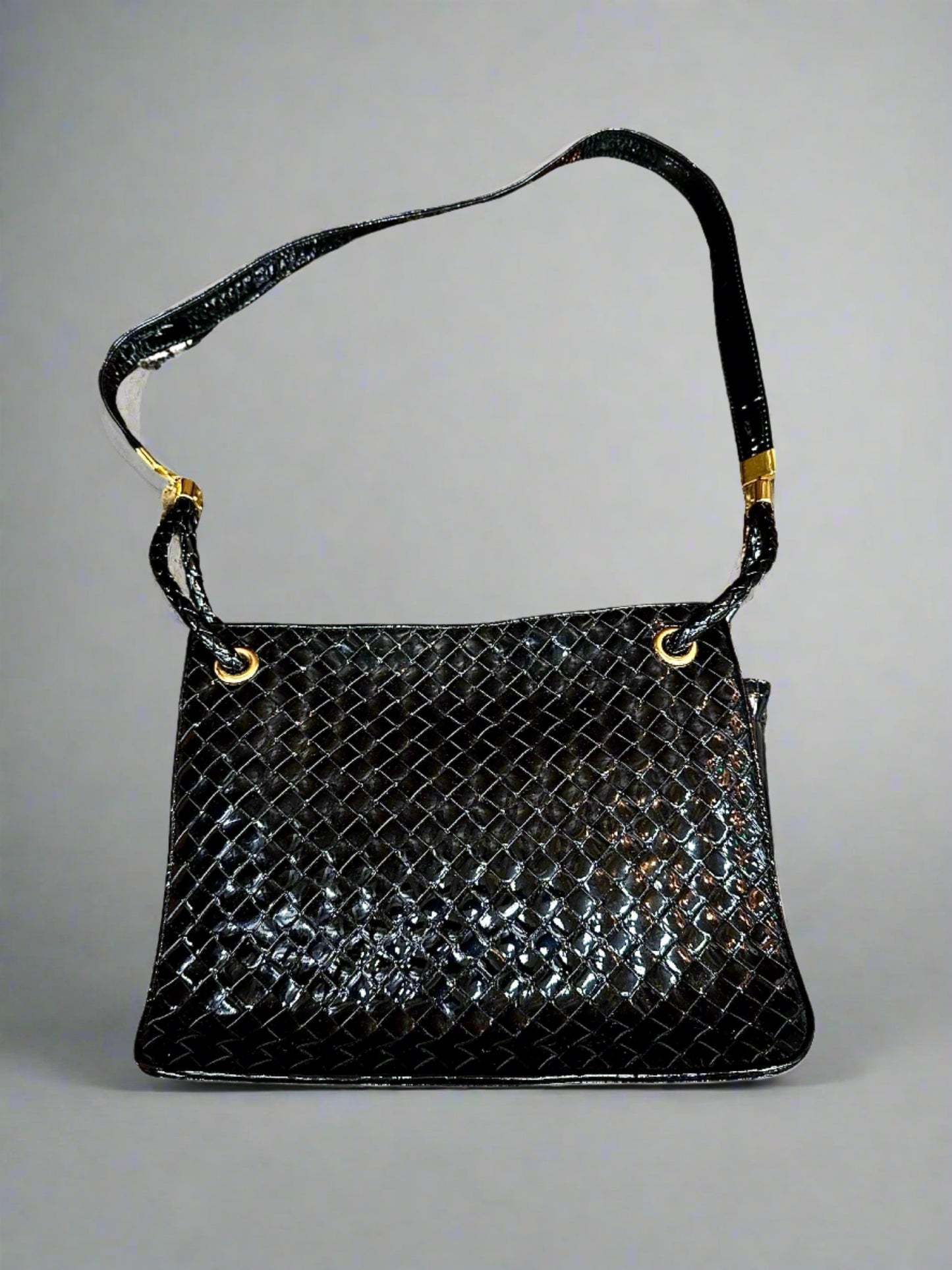 Black patent leather woven texture bag with gold hardware and misshaped shoulder strap