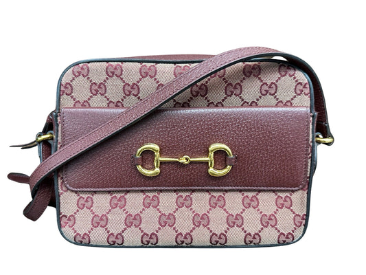 Front of burgundy Gucci bag with flap on the front and gold hardware