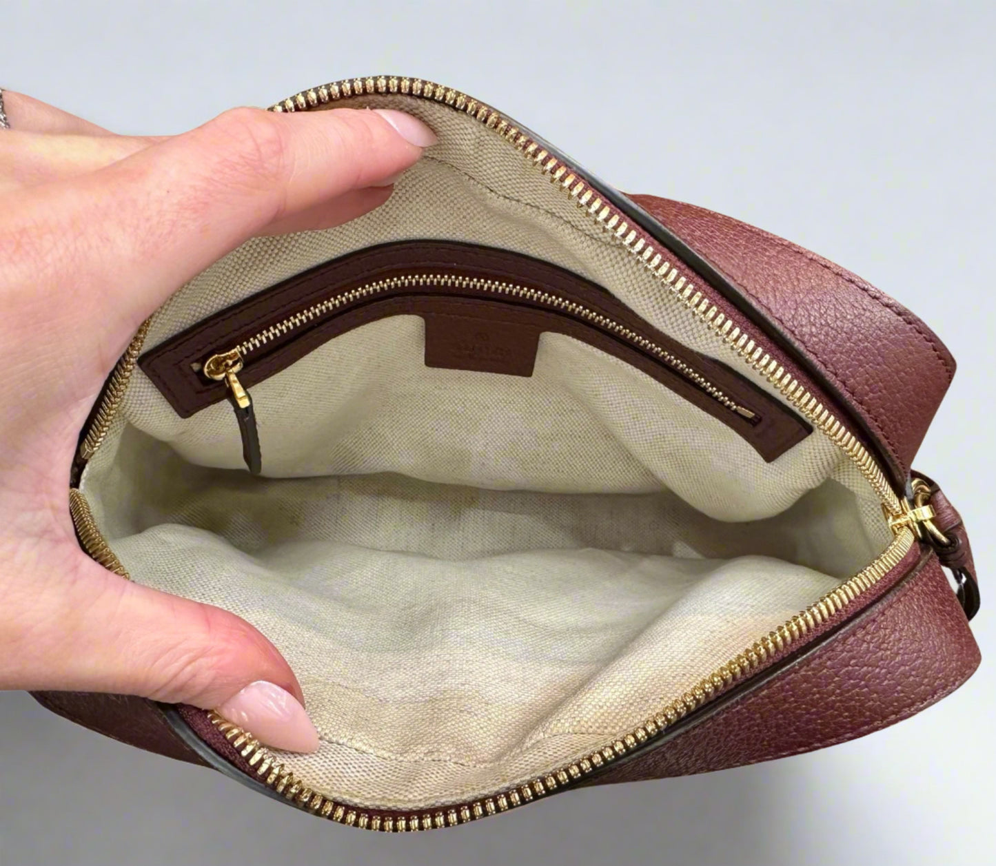 Interior of bag with cream colored fabric and light stains
