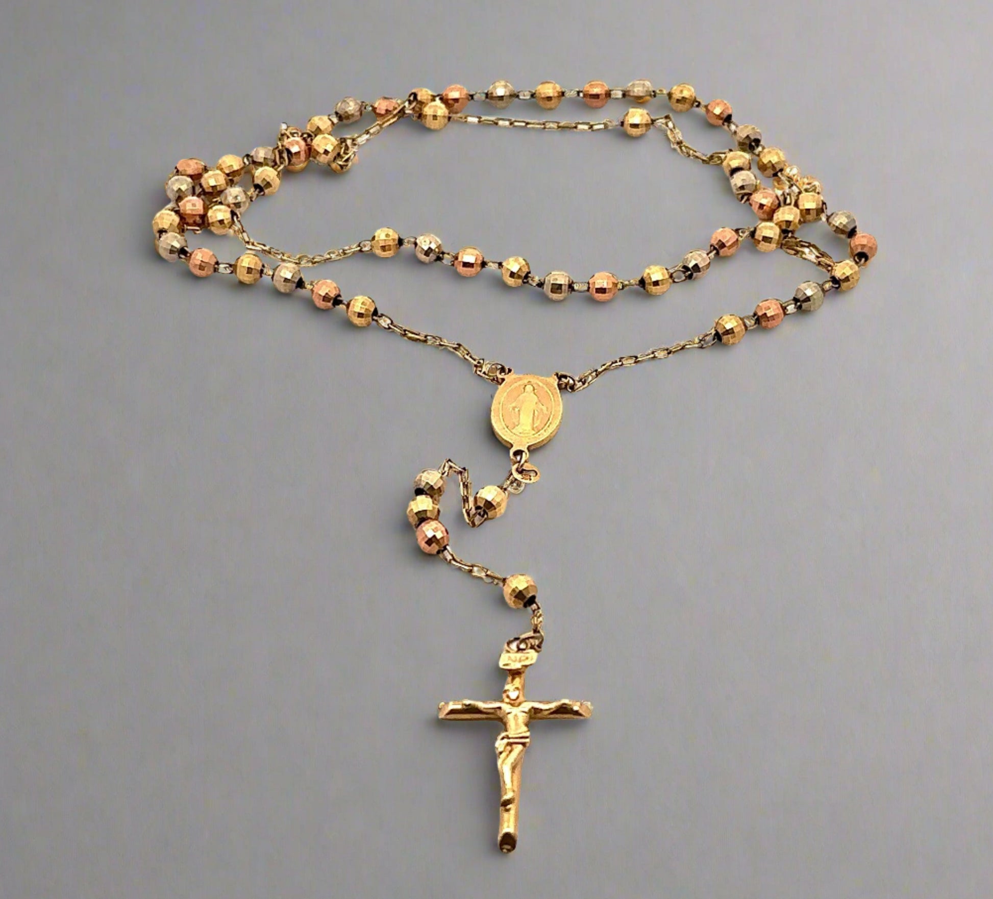 14K multi color gold rosary with a yellow gold cross. The chain is double up to fit in the photo