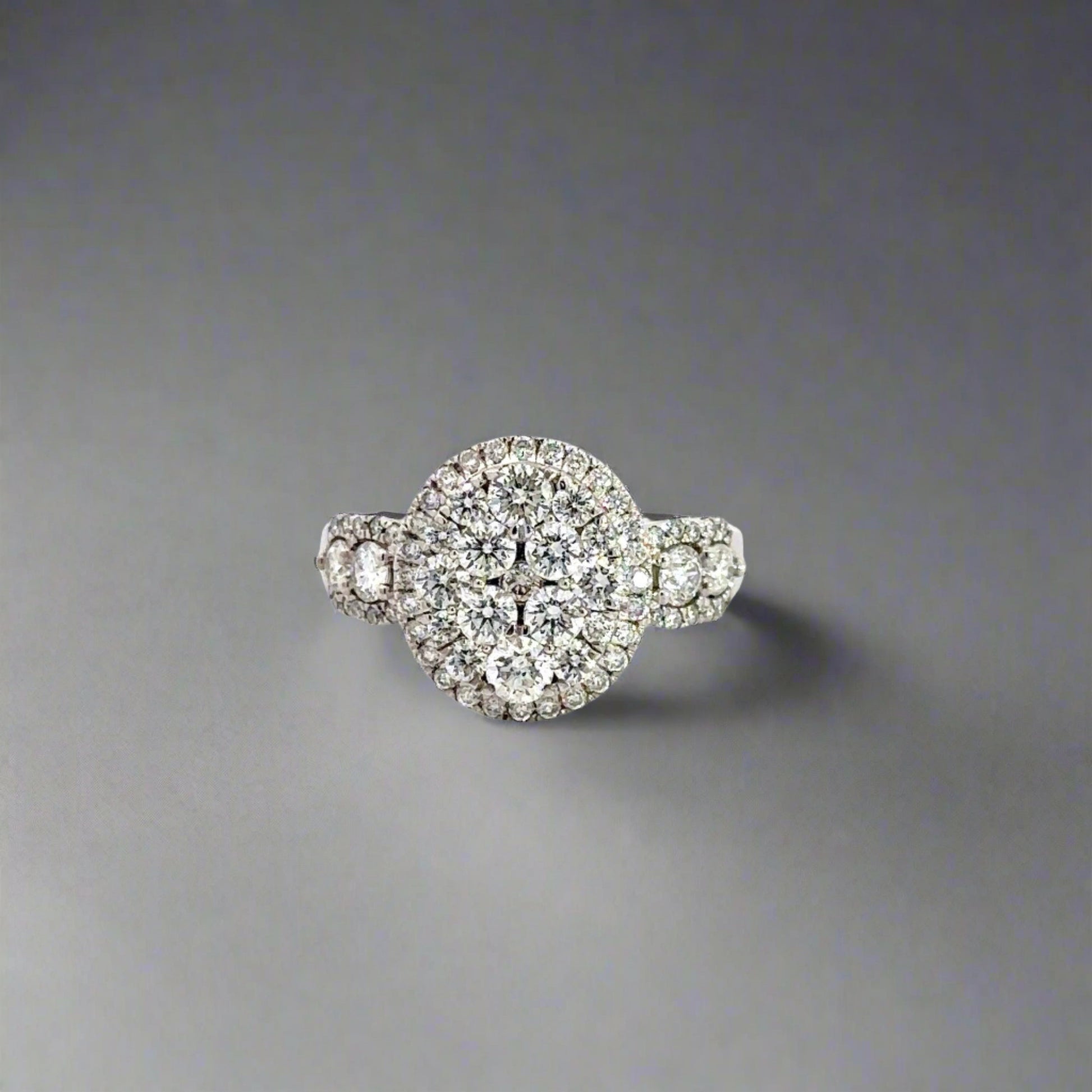 Front of white gold oval-shaped diamond cluster ring with round diamonds in various sizes.